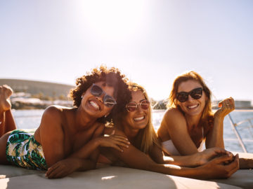 Three Women on a boat looking to camera and smiling, thinking about New Year's Resolutions For Fertility